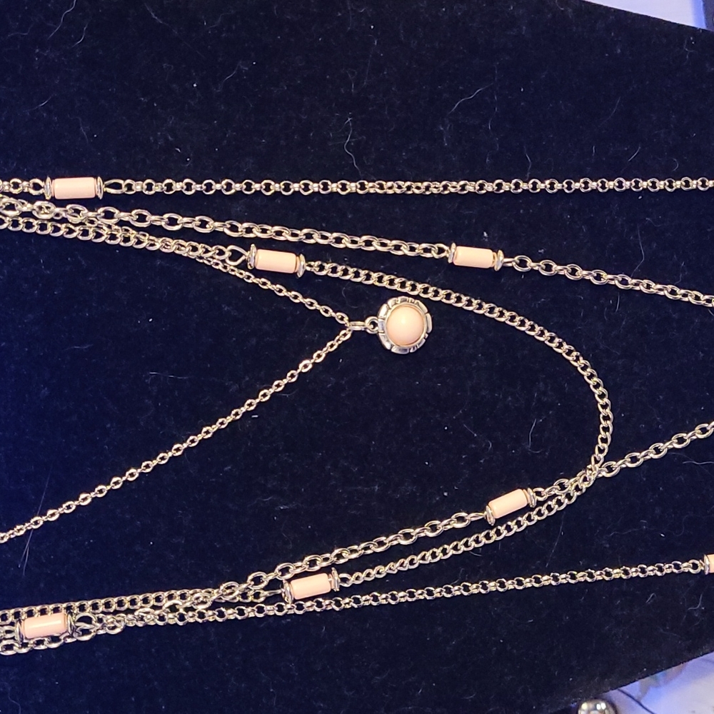 long multi strand pink and silver necklace with a key